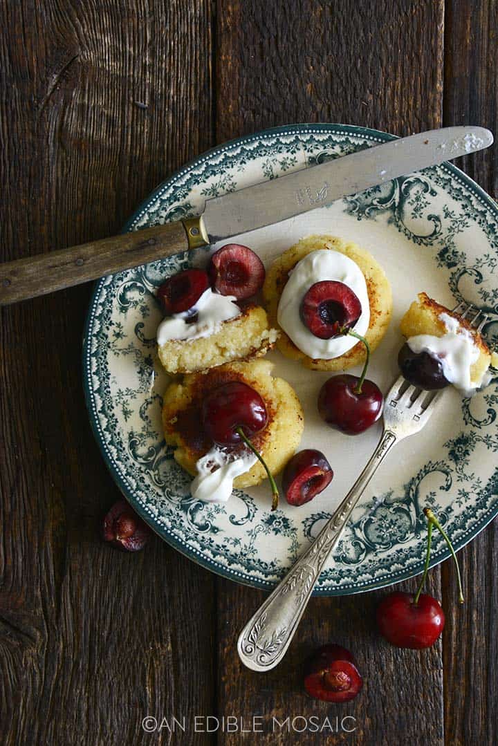 Syrniki with Sour Cream and Fresh Cherries on Vintage Plate