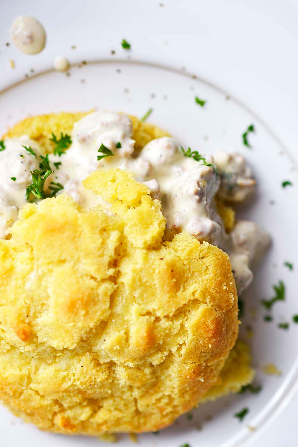 close up top view of low carb keto biscuits with creamy white sausage gravy