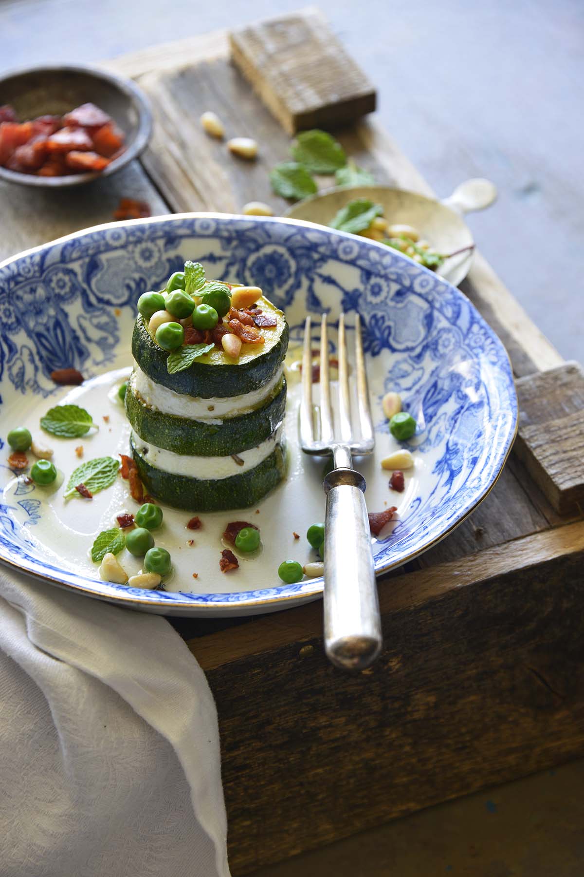 front view of cold zucchini appetizer on blue and white plate on top of wooden crate