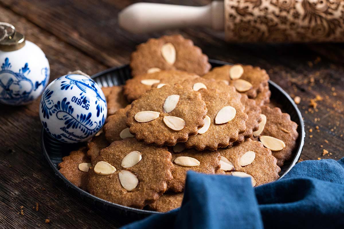 rustic plate with spiced almond cookies and embossed rolling pin in background