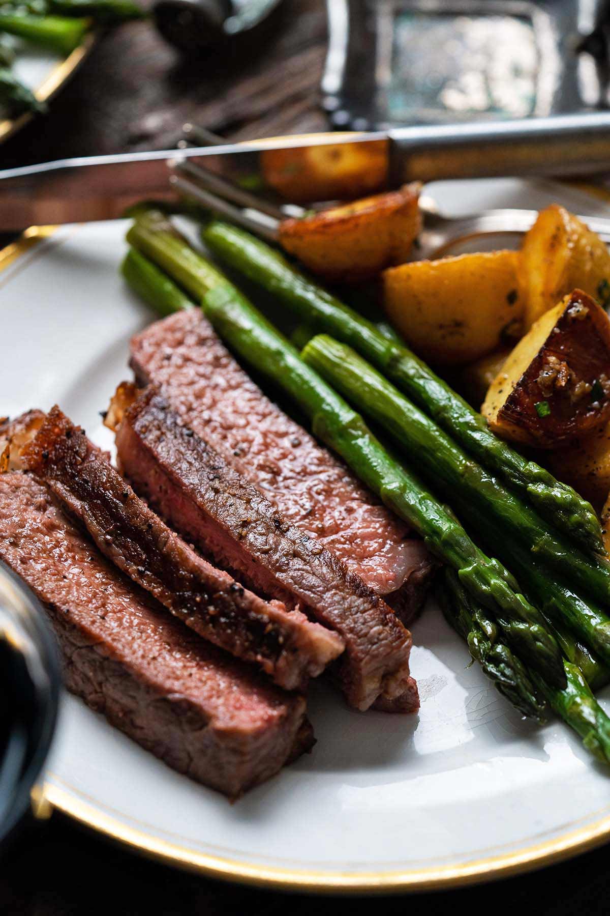 close up of sliced grilled ribeye on white ceramic plate