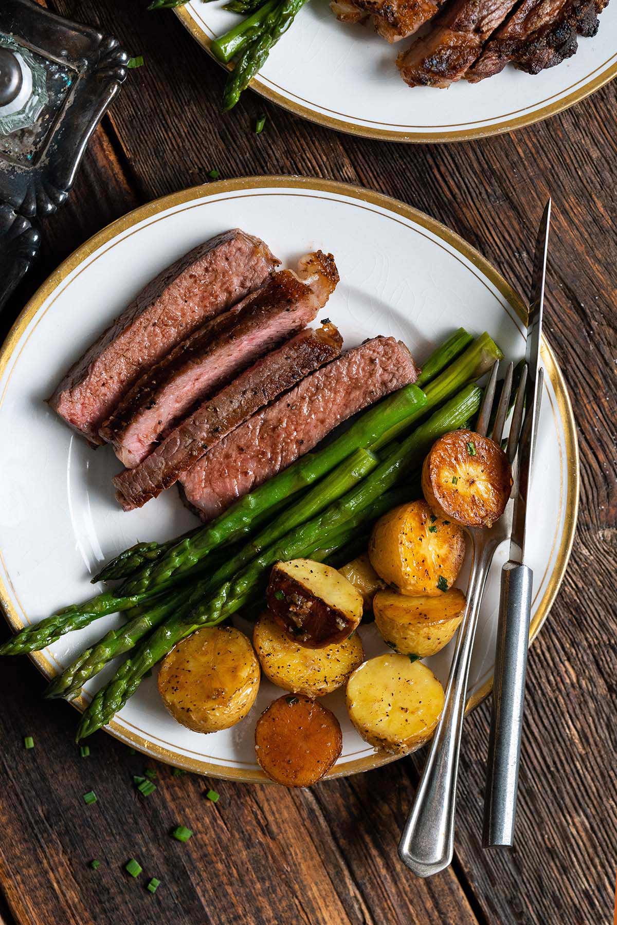 grilled ribeye steak dinner with potatoes and asparagus