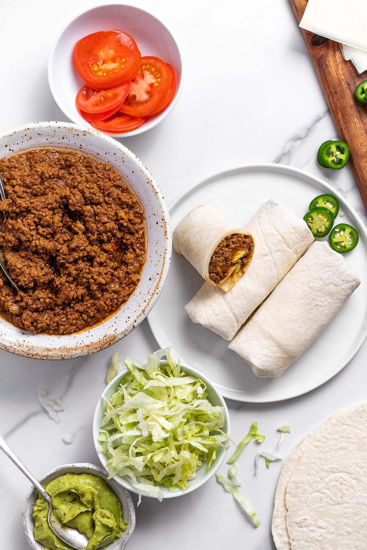 top view of taco spread with seasoned ground beef guacamole and tortillas