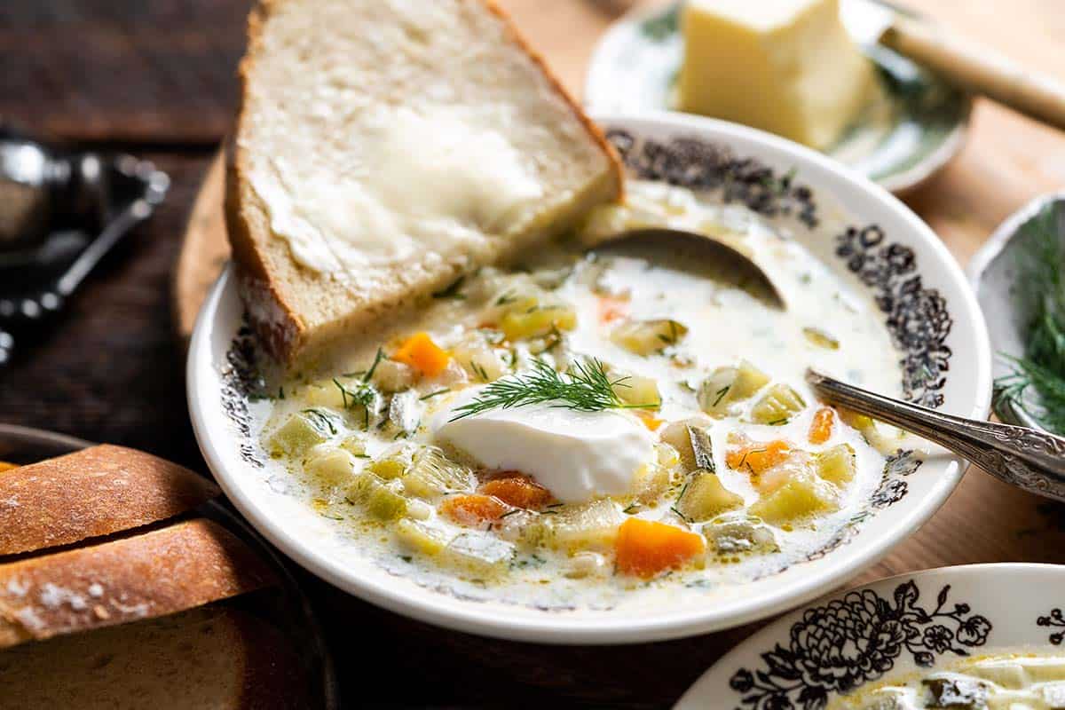 bowl of creamy polish soup with sourdough bread and butter