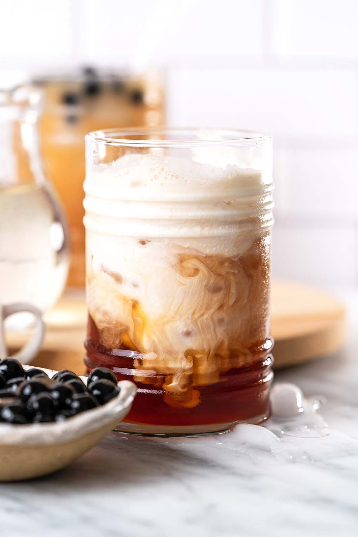 half and half swirling in iced tea to make boba bubble tea drink