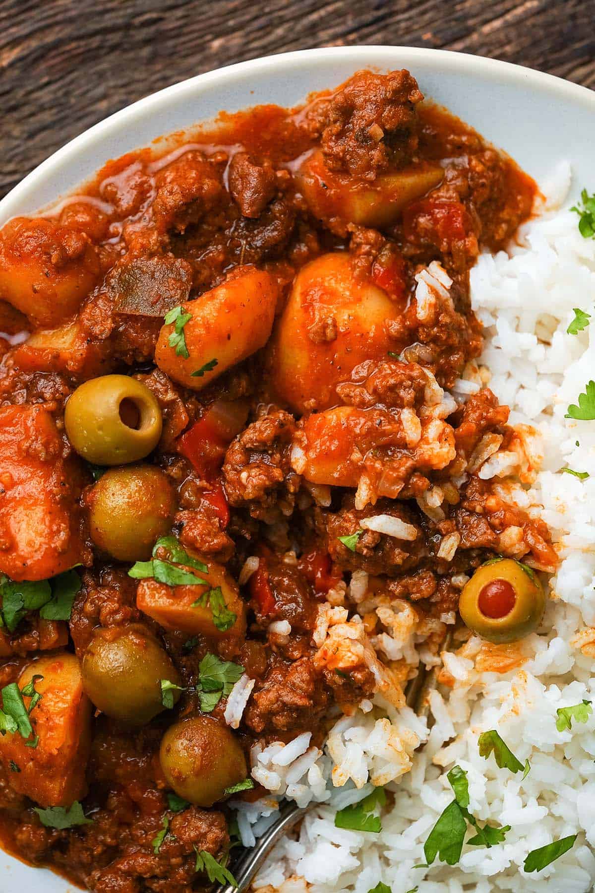 close up top view of picadillo with ground beef and potatoes on rice