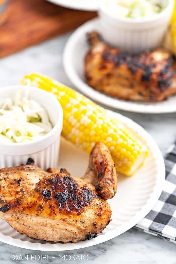 marinated chicken on plate with corn and coleslaw