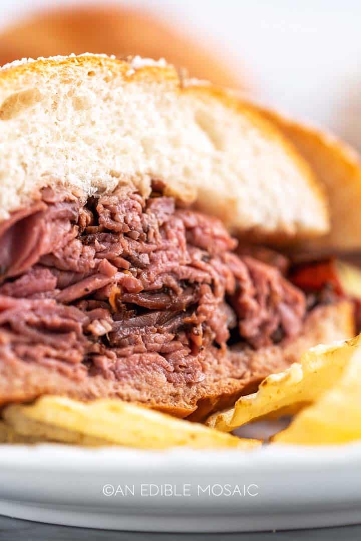 close up of sliced roast beef on kummelweck roll