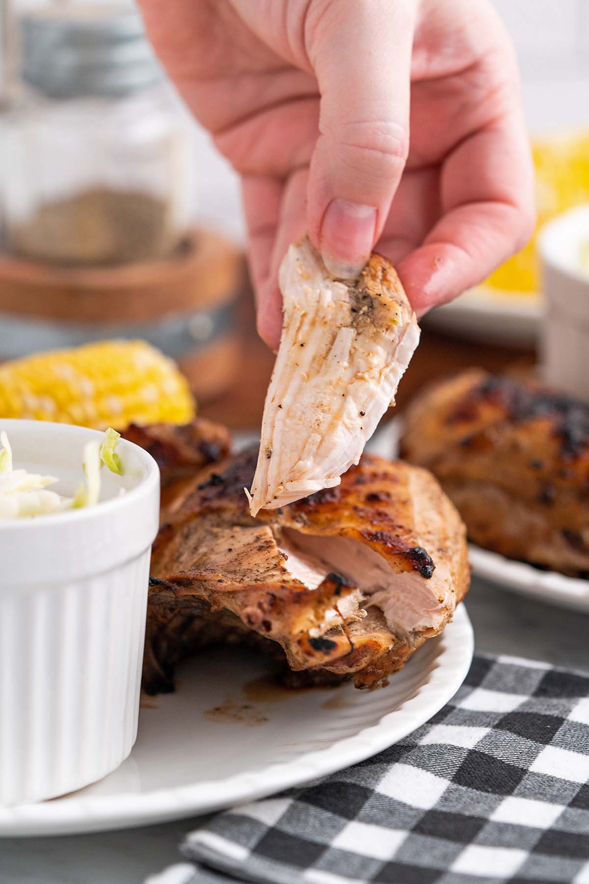 hand holding piece of juicy charbroiled chicken