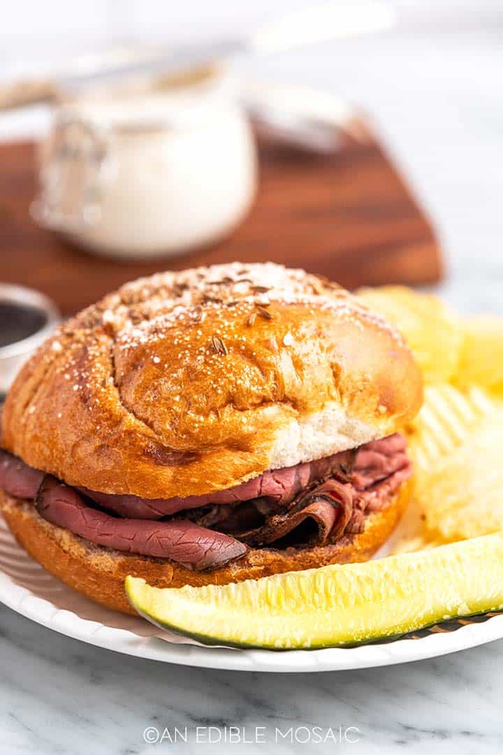 roast beef sandwich with chips and pickle