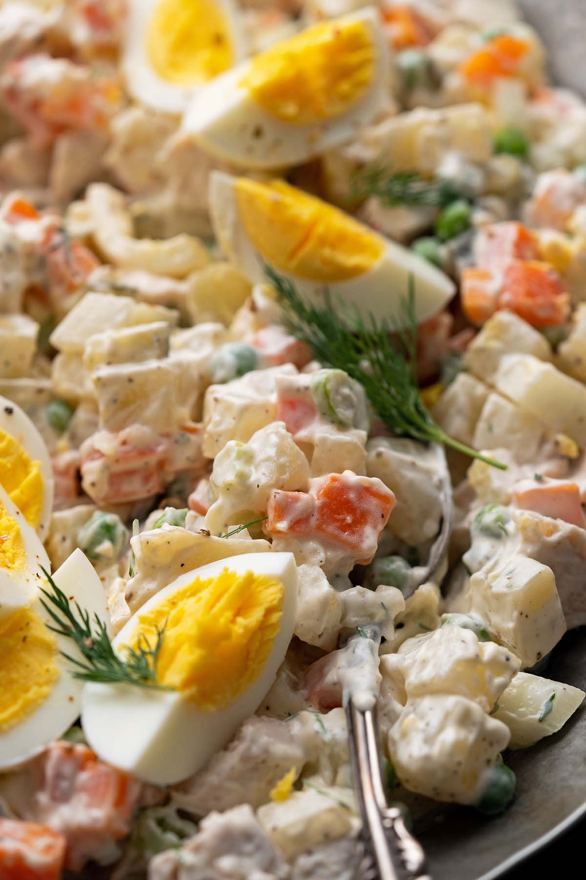 close up of russian potato salad with mayo and eggs and chicken