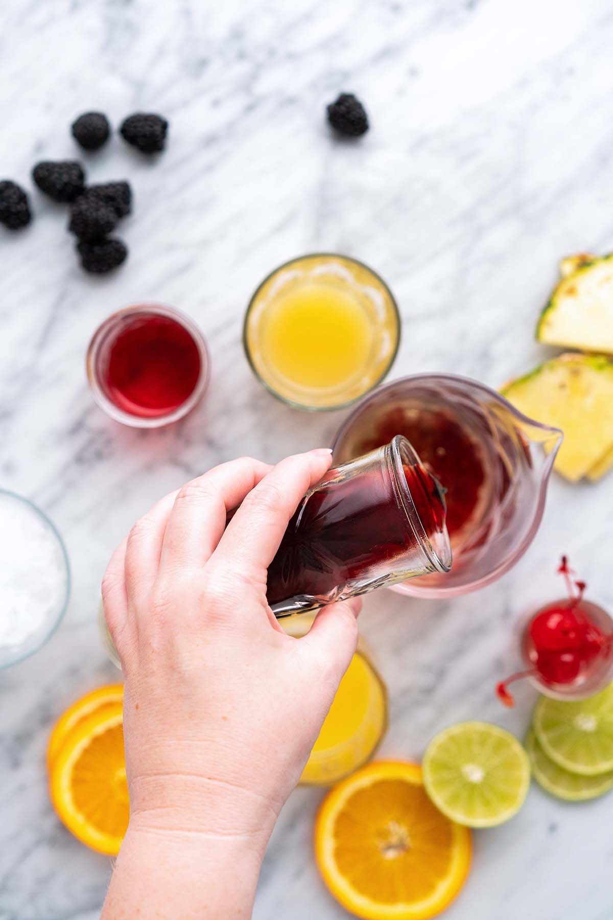 hand pouring liquor into pitcher for rum runner