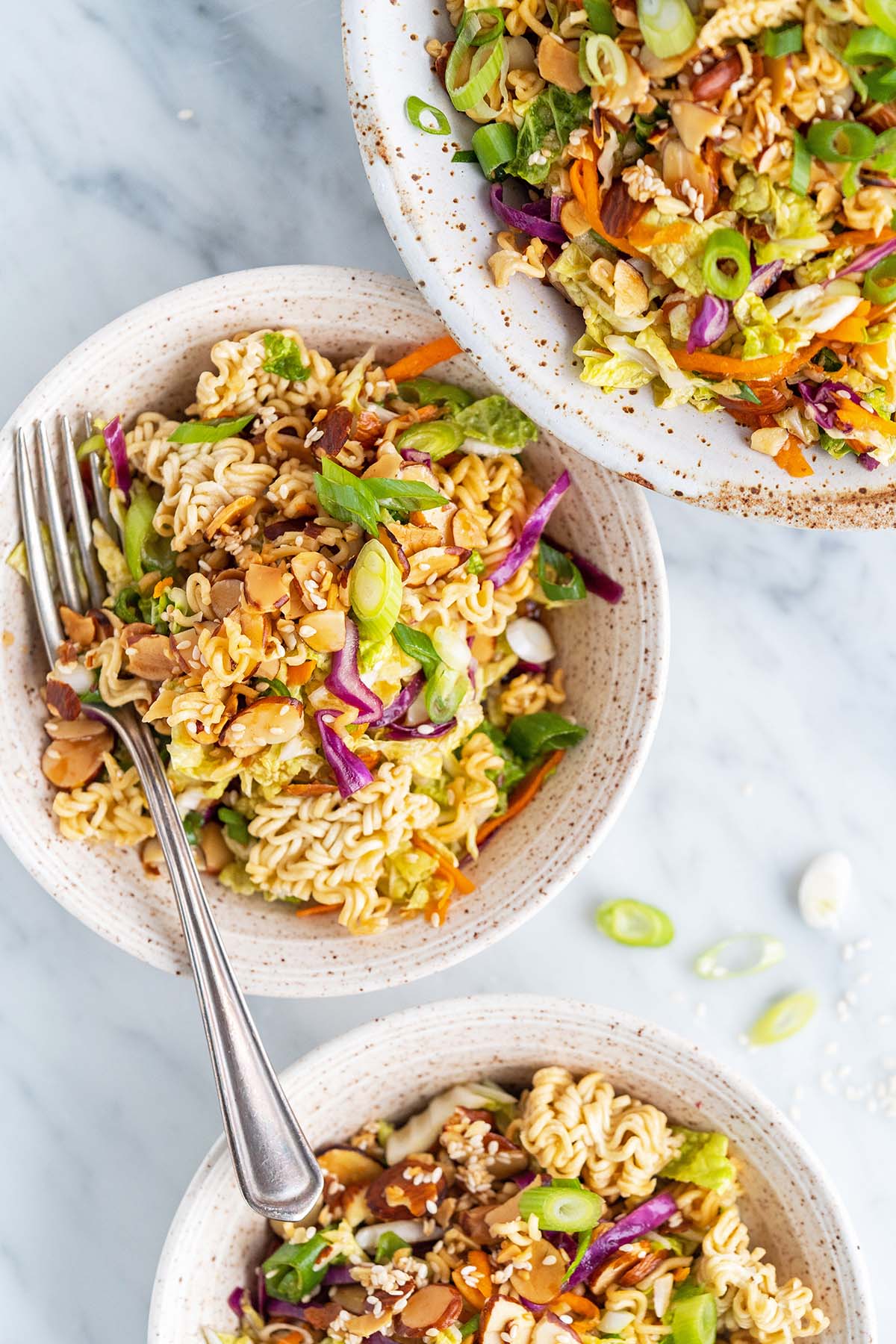 close up top view of bowls of asian slaw with ramen noodles