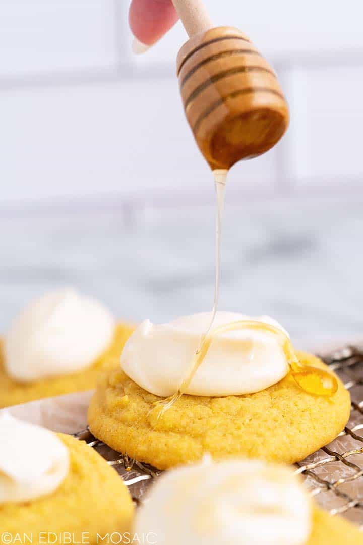 drizzling honey on top of buttercream on cornbread cookies