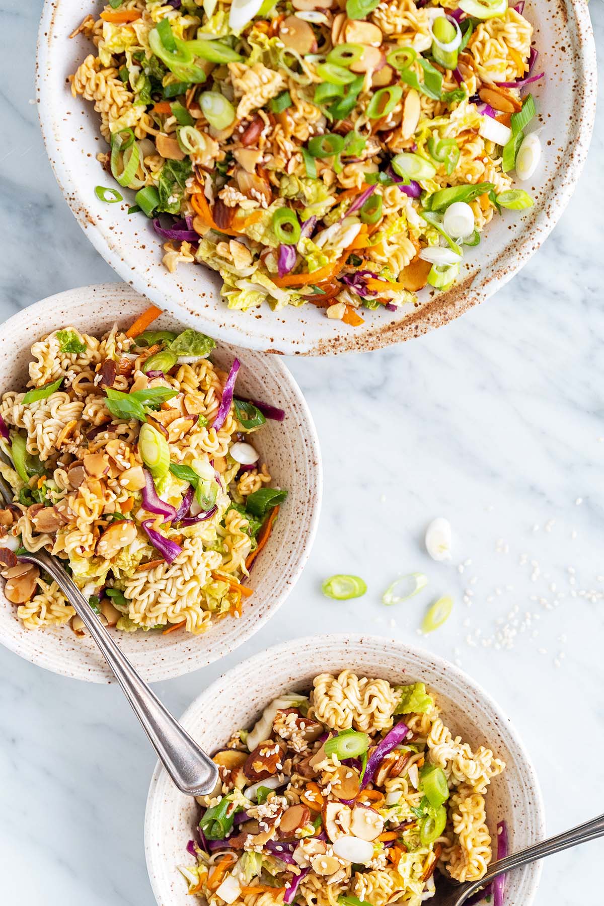 top view of 3 bowls of cabbage and ramen noodle salad