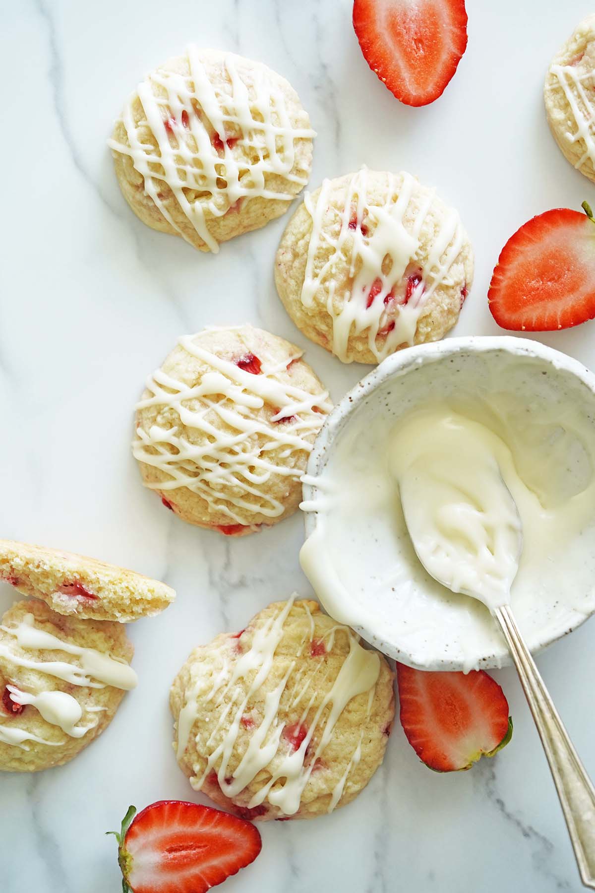 top view of homemade strawberry cookies with vanilla glaze and fresh berries