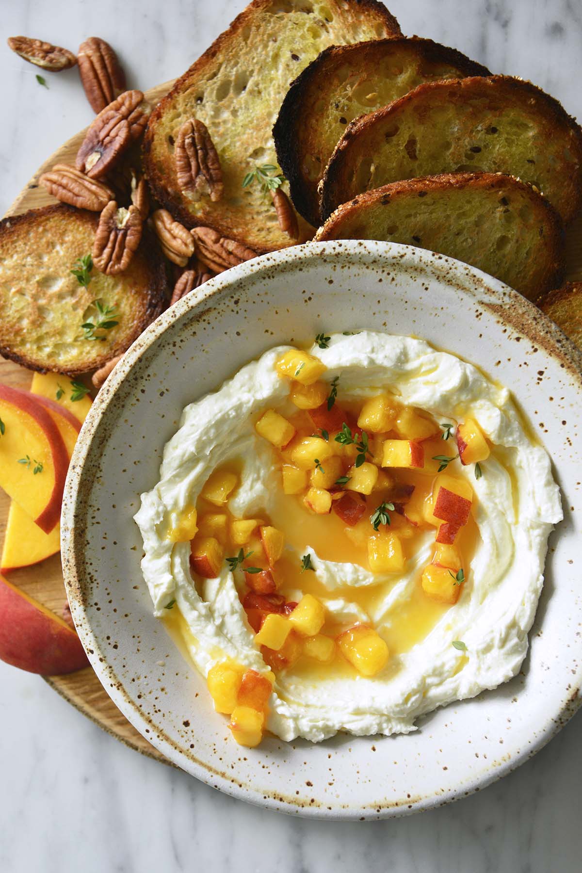 top view of stoneware bowl with creamy whipped feta and honey peaches