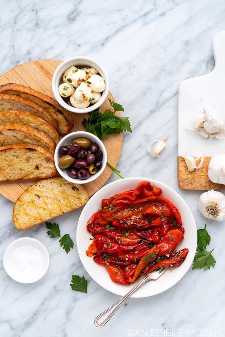 spread of marinated peppers bread and olives