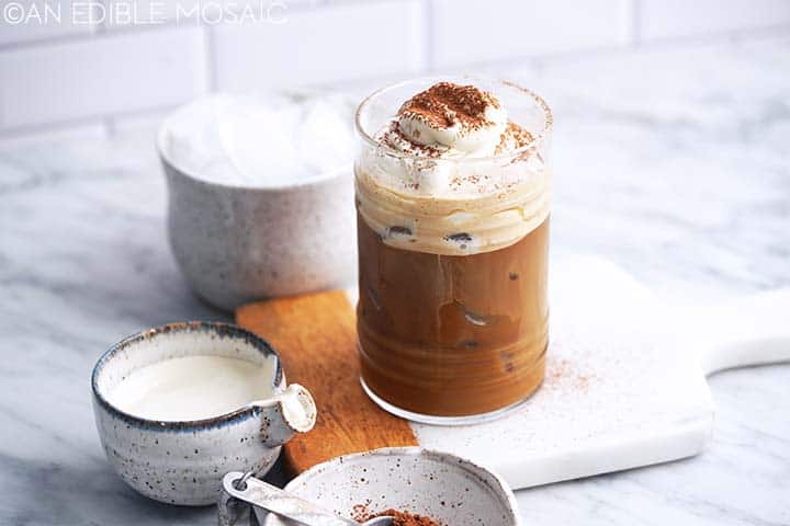 tiramisu latte with mascarpone cream topping in glass