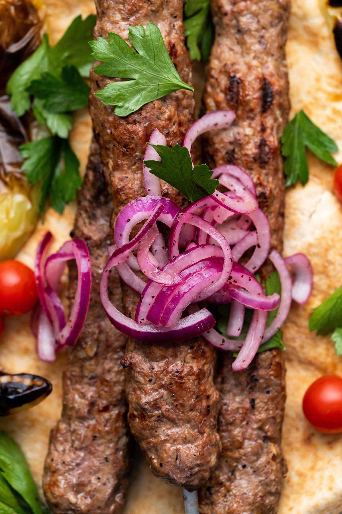 close up top view of adana kebap with sumac onions