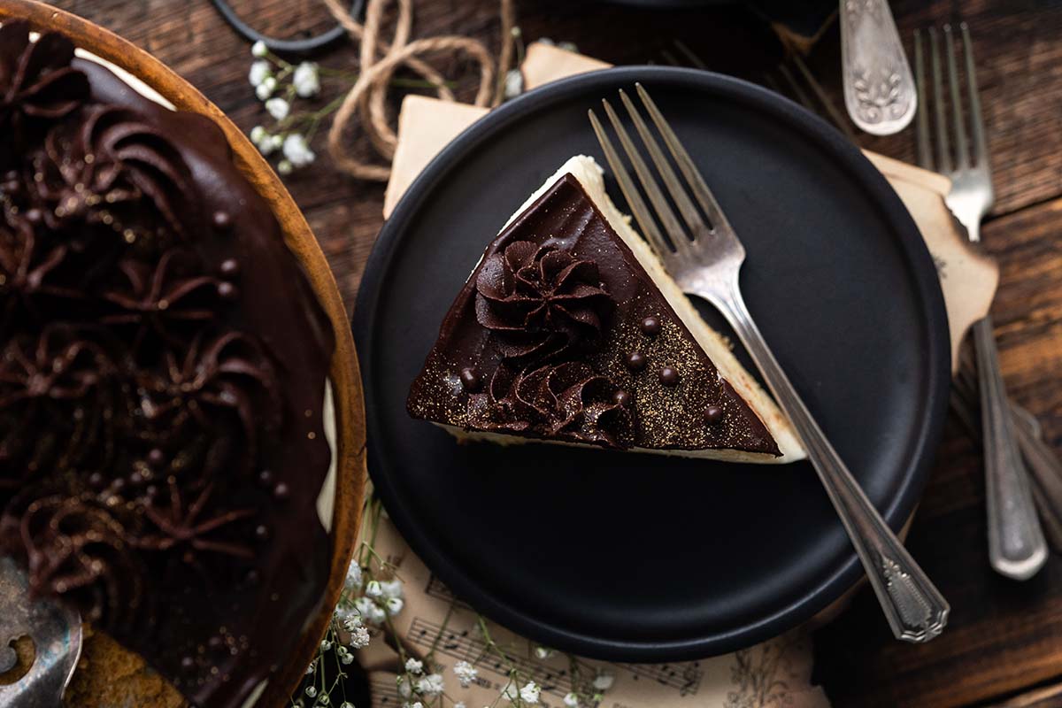 decadent bird's milk cake on stand with slice on plate