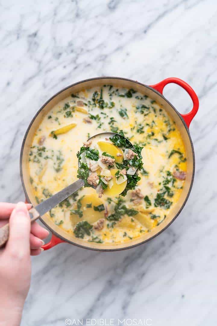 ladle full of creamy sausage tuscan soup