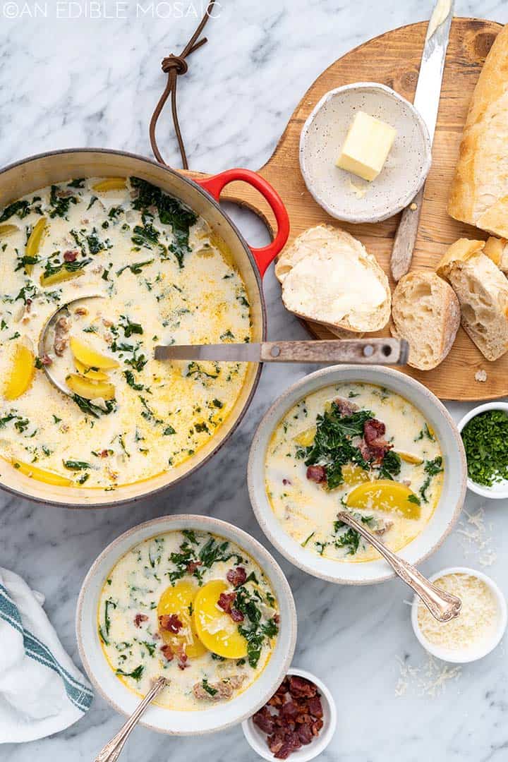 pot of zuppa toscana with bowls and bread