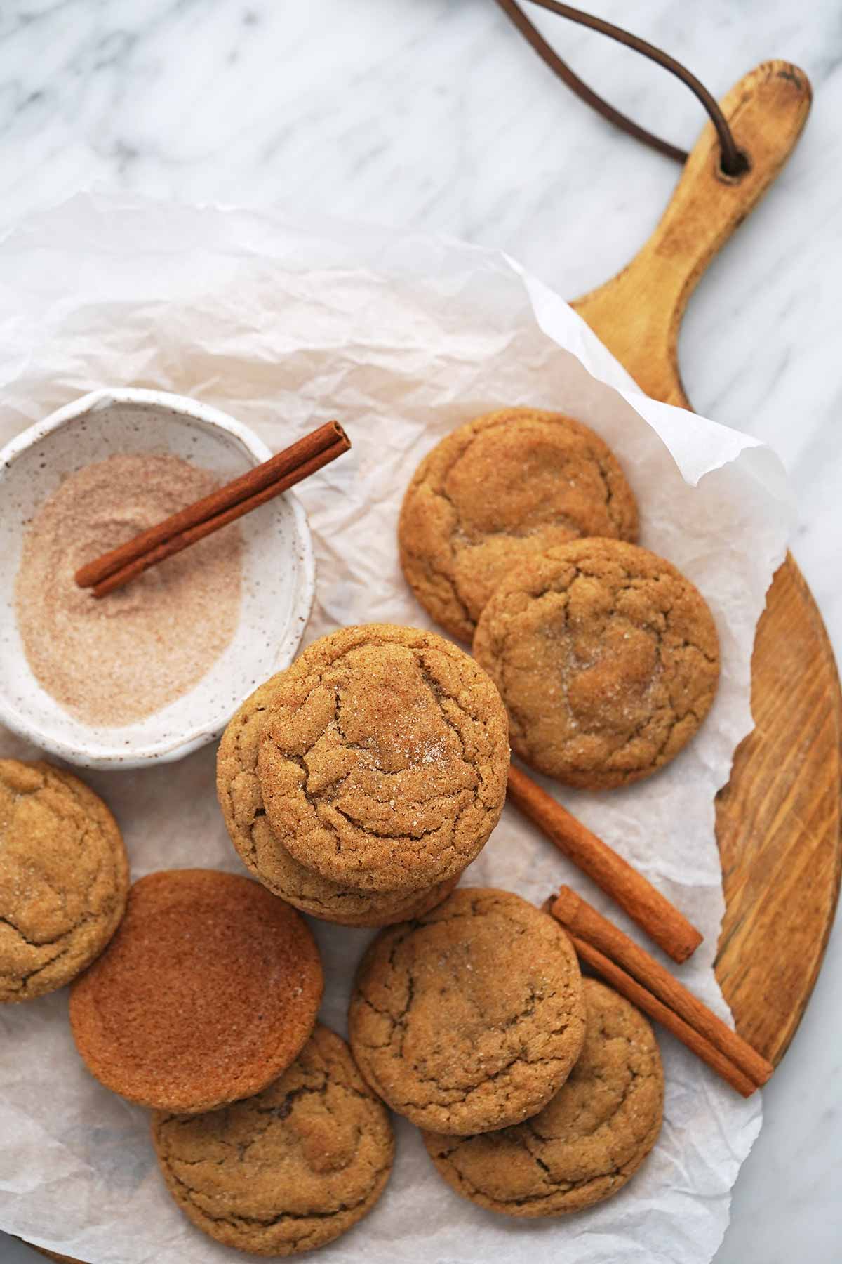 top view of pie of chewy apple cinnamon cookies on wooden cutting board on marble countertop