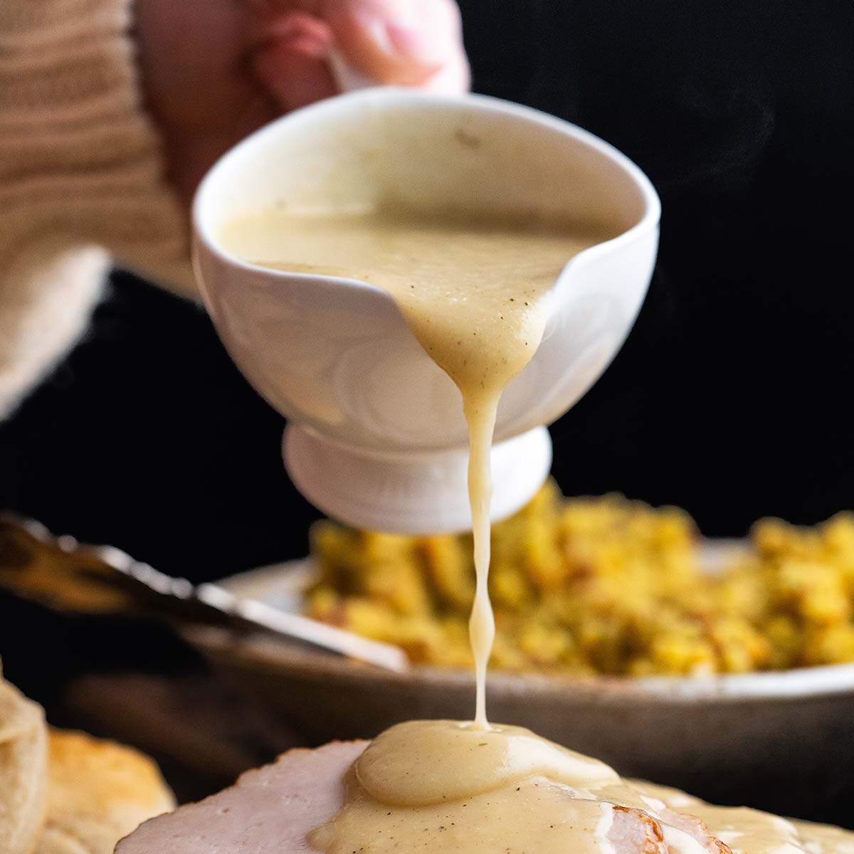 pouring gravy onto turkey breast