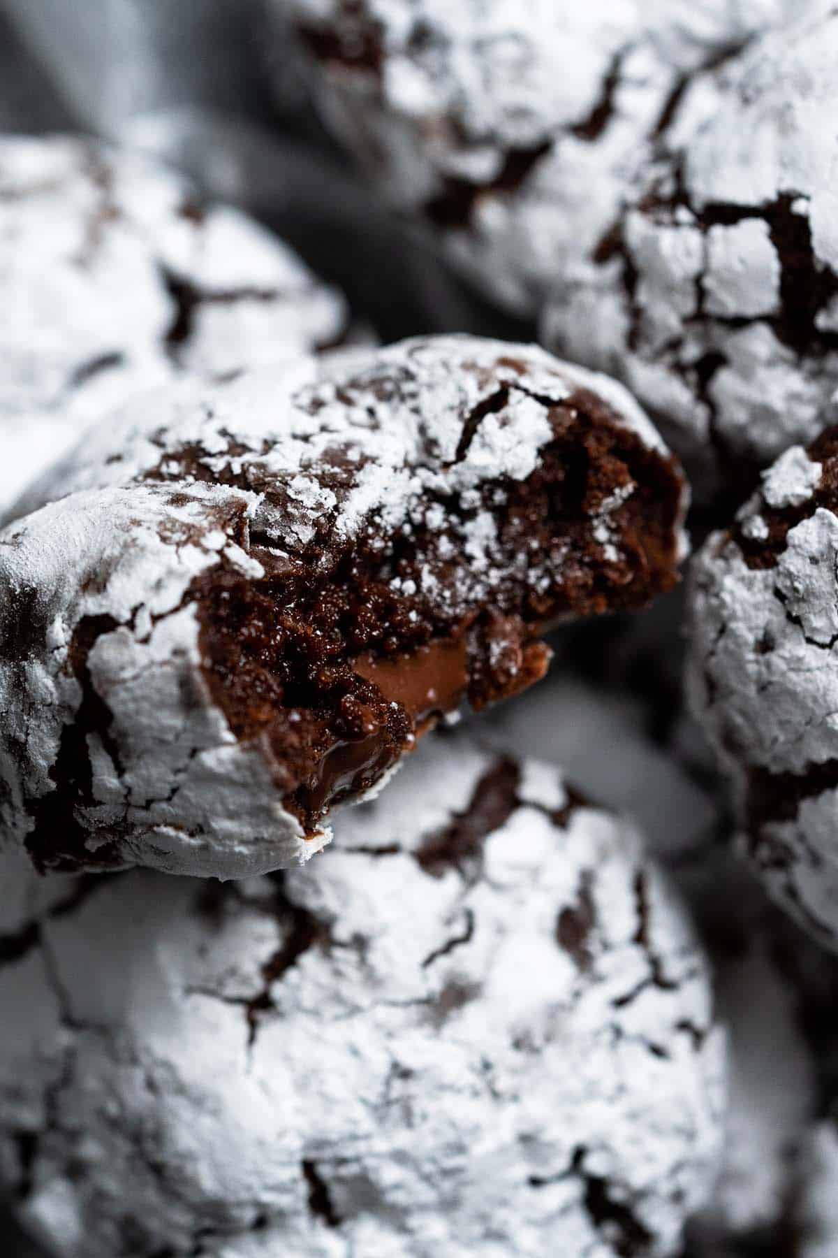 close up of crinkle cookie with bite showing brownie like interior