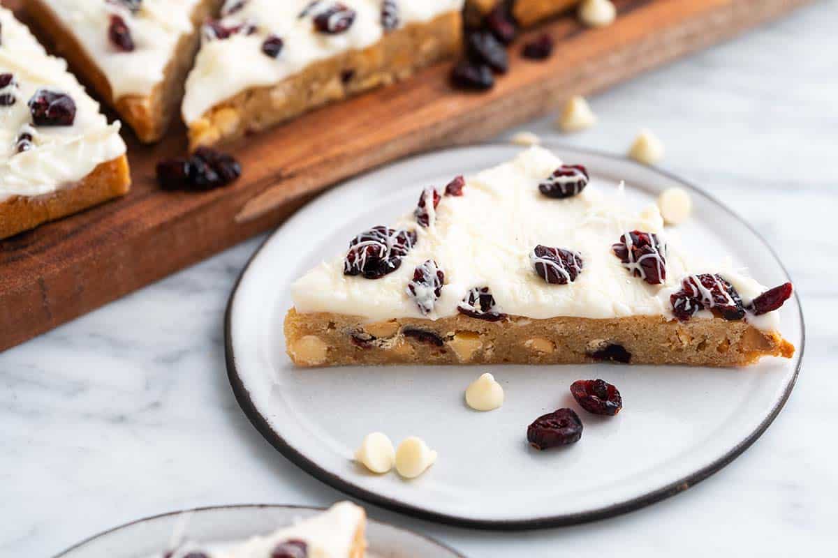 cranberry bliss bar on small white plate with black rim