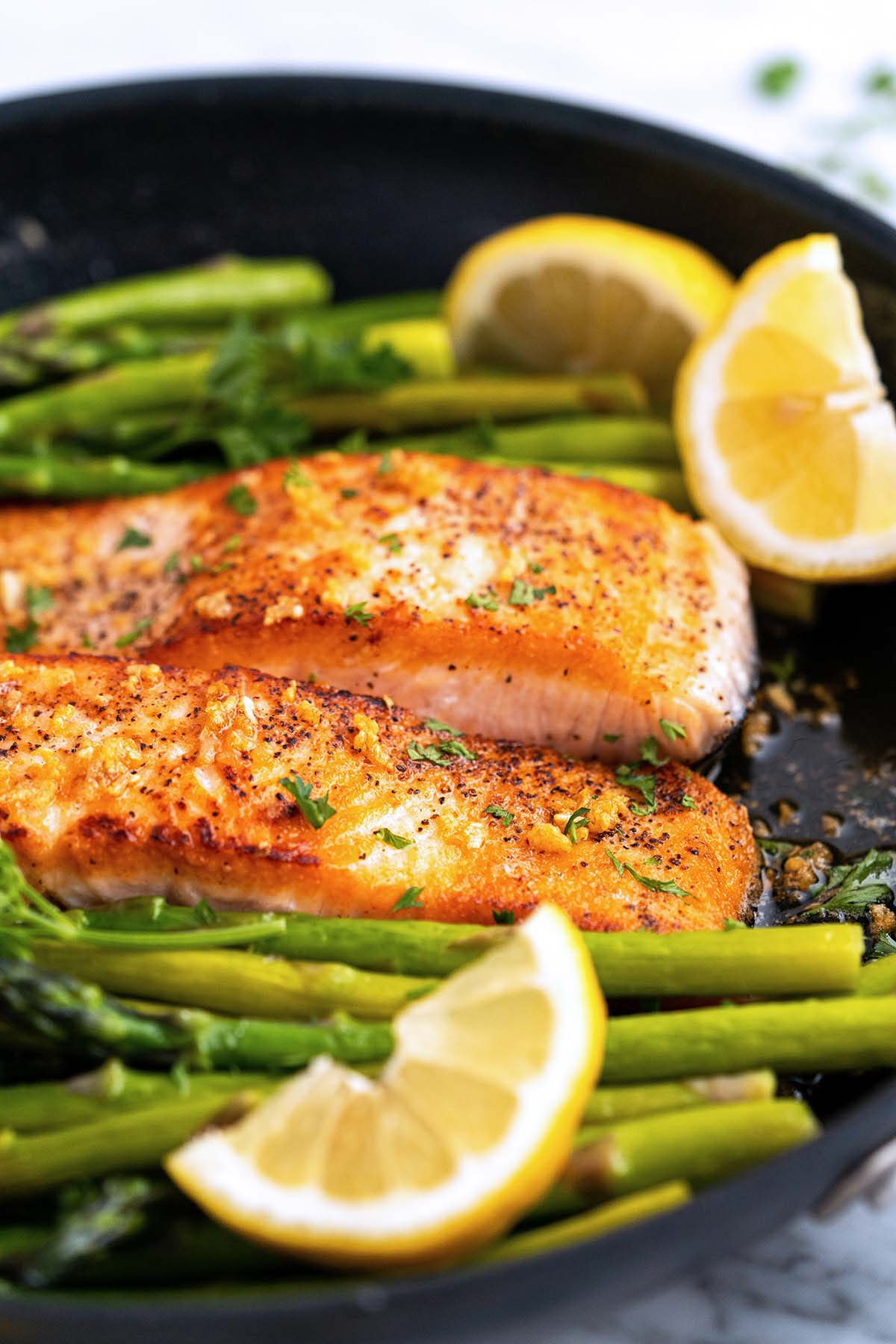 lemon garlic butter salmon with asparagus in frying pan