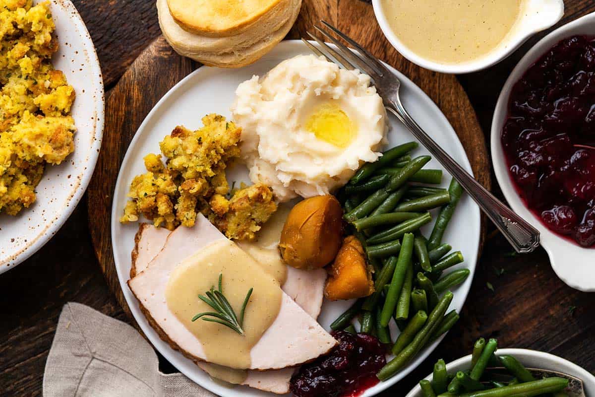plate of traditional thanksgiving dinner with turkey and side dishes