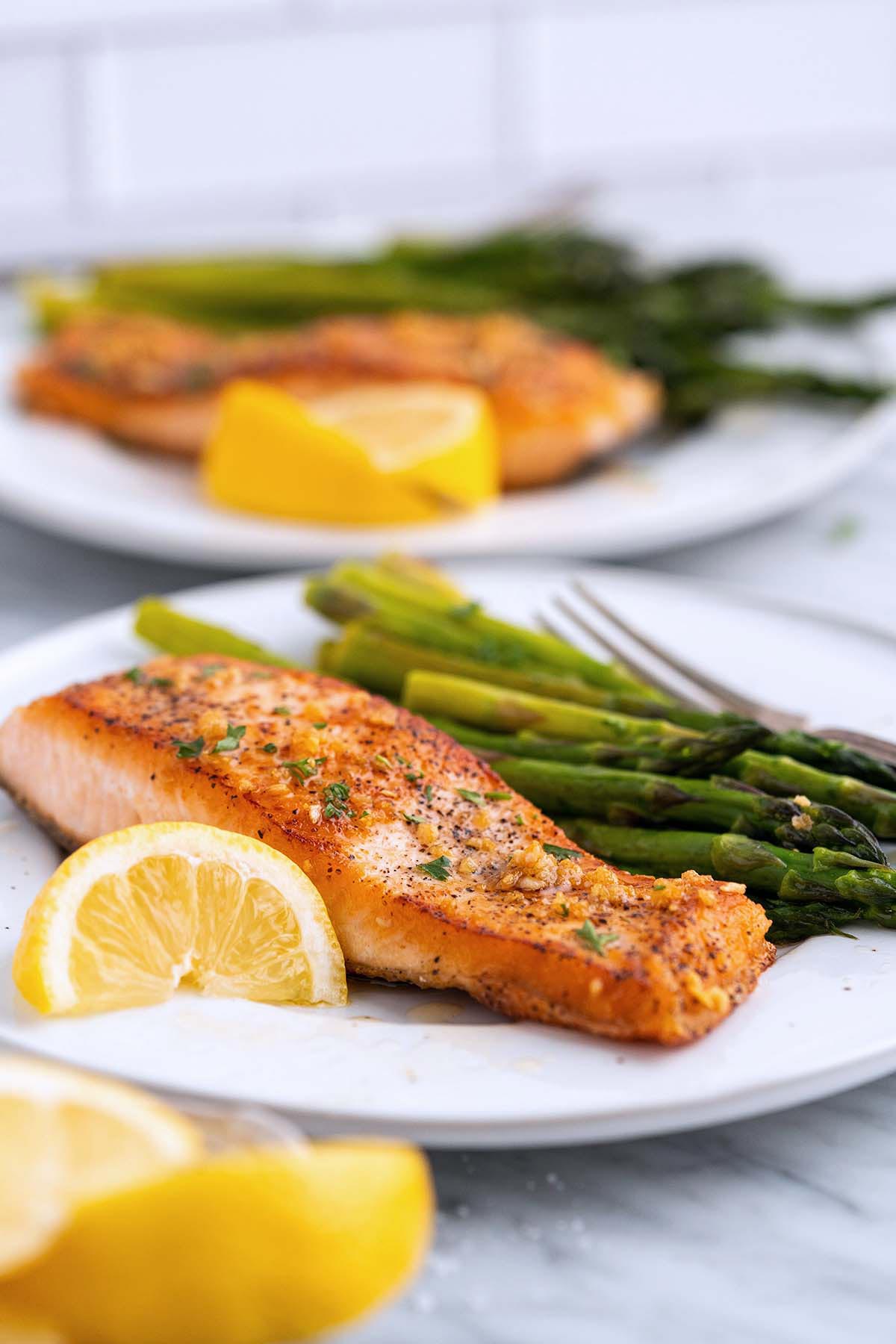 restaurant quality salmon dinner on plate with asparagus and lemon