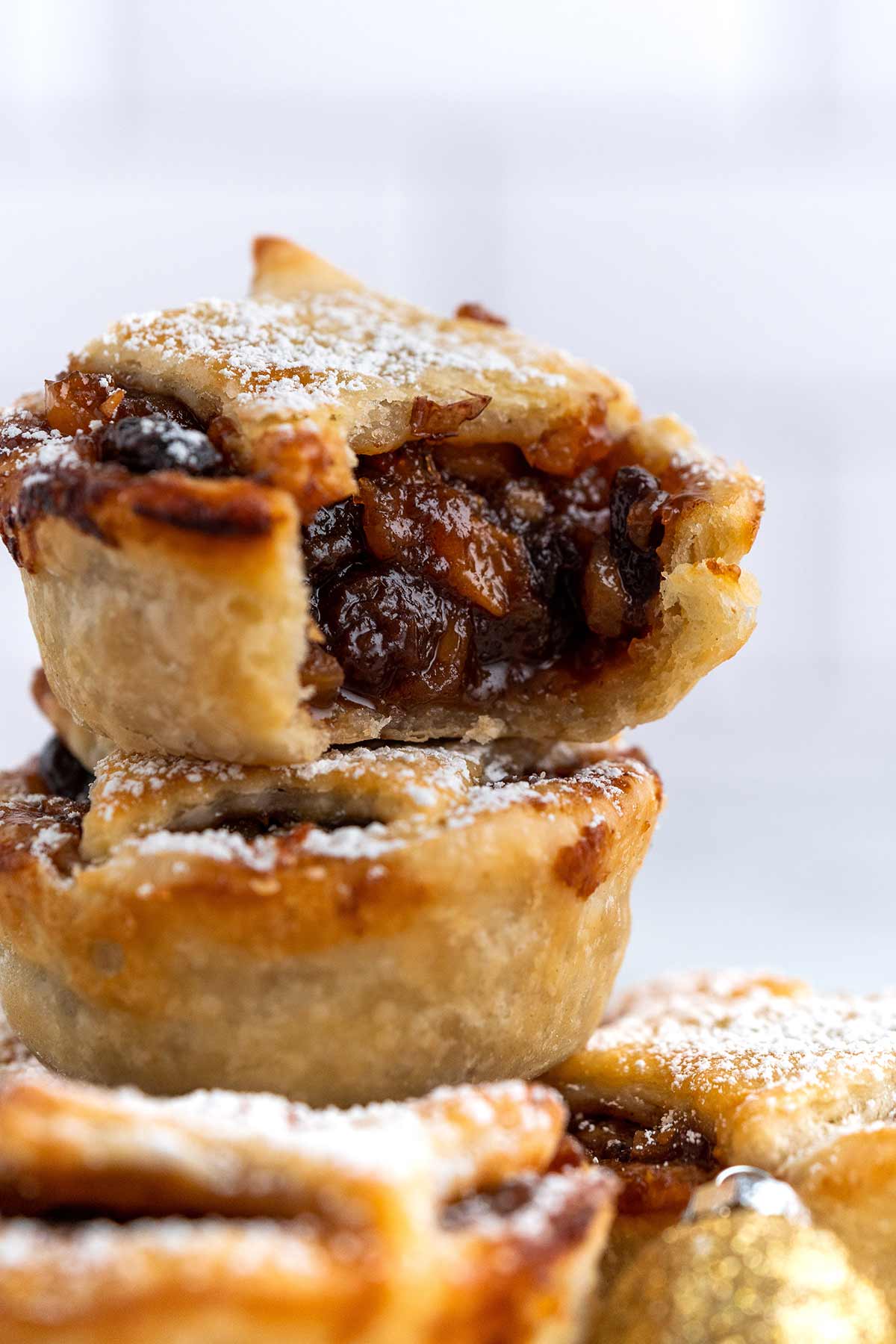 stack of mincemeat tarts with bite taken out of top one to show filling
