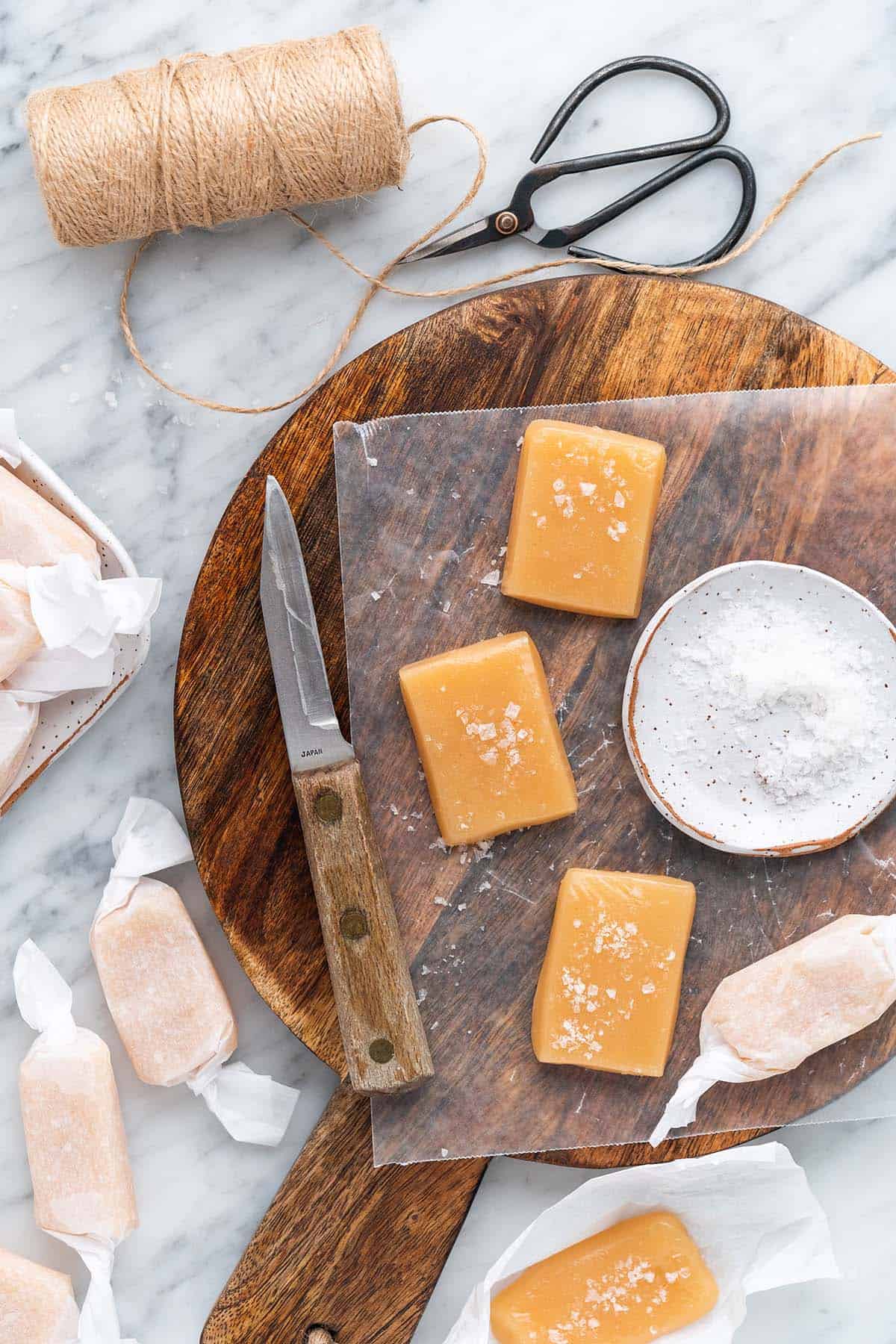 top view of salted caramels on wooden board on marble countertop