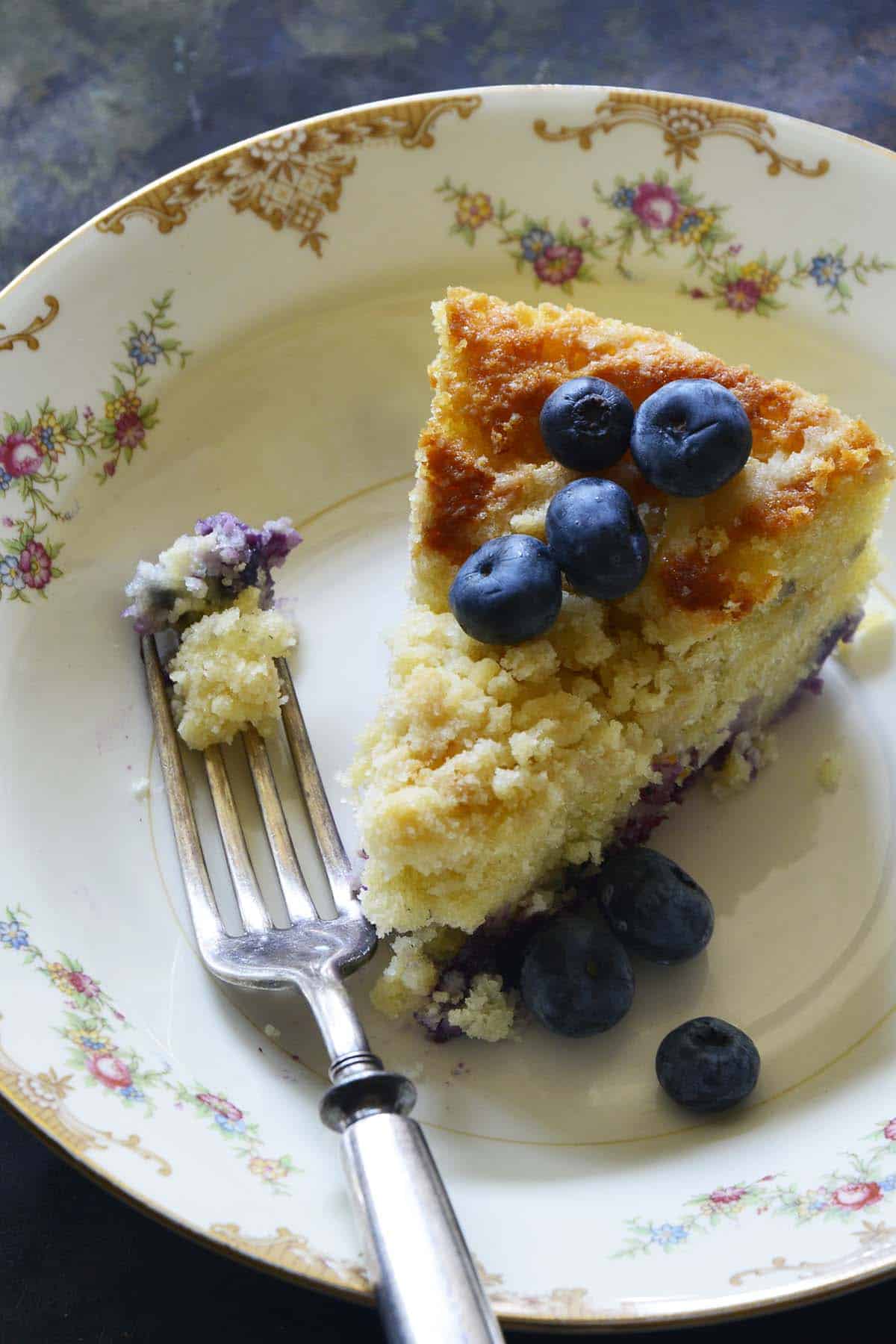 close up of piece of blueberry cake with forkful