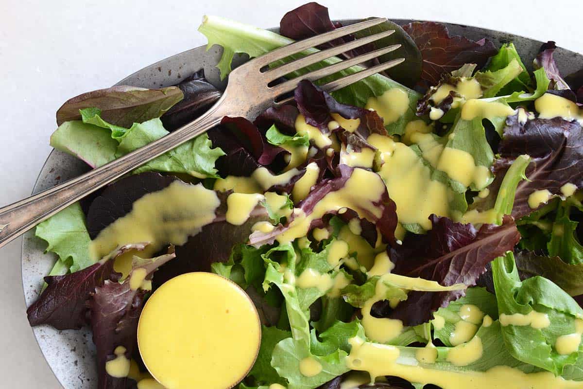 close up view of salad greens with mango vinaigrette salad dressing