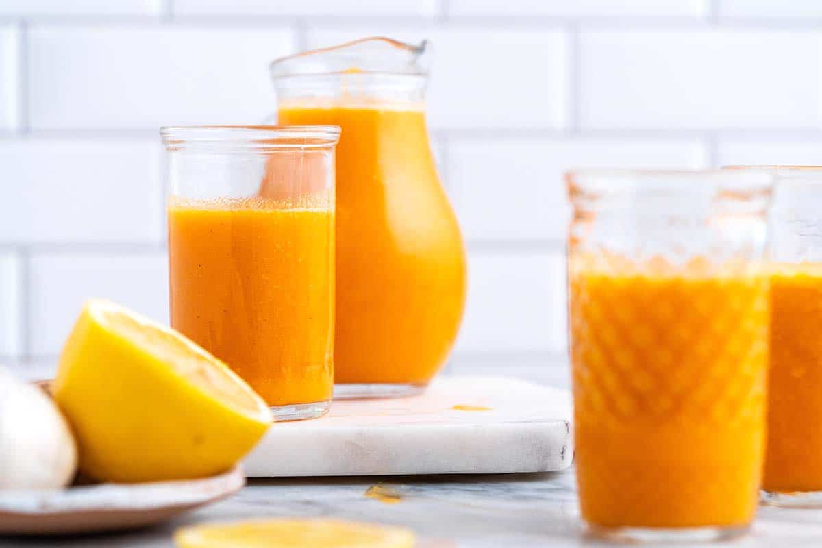cold pressed juice in glasses and small pitcher