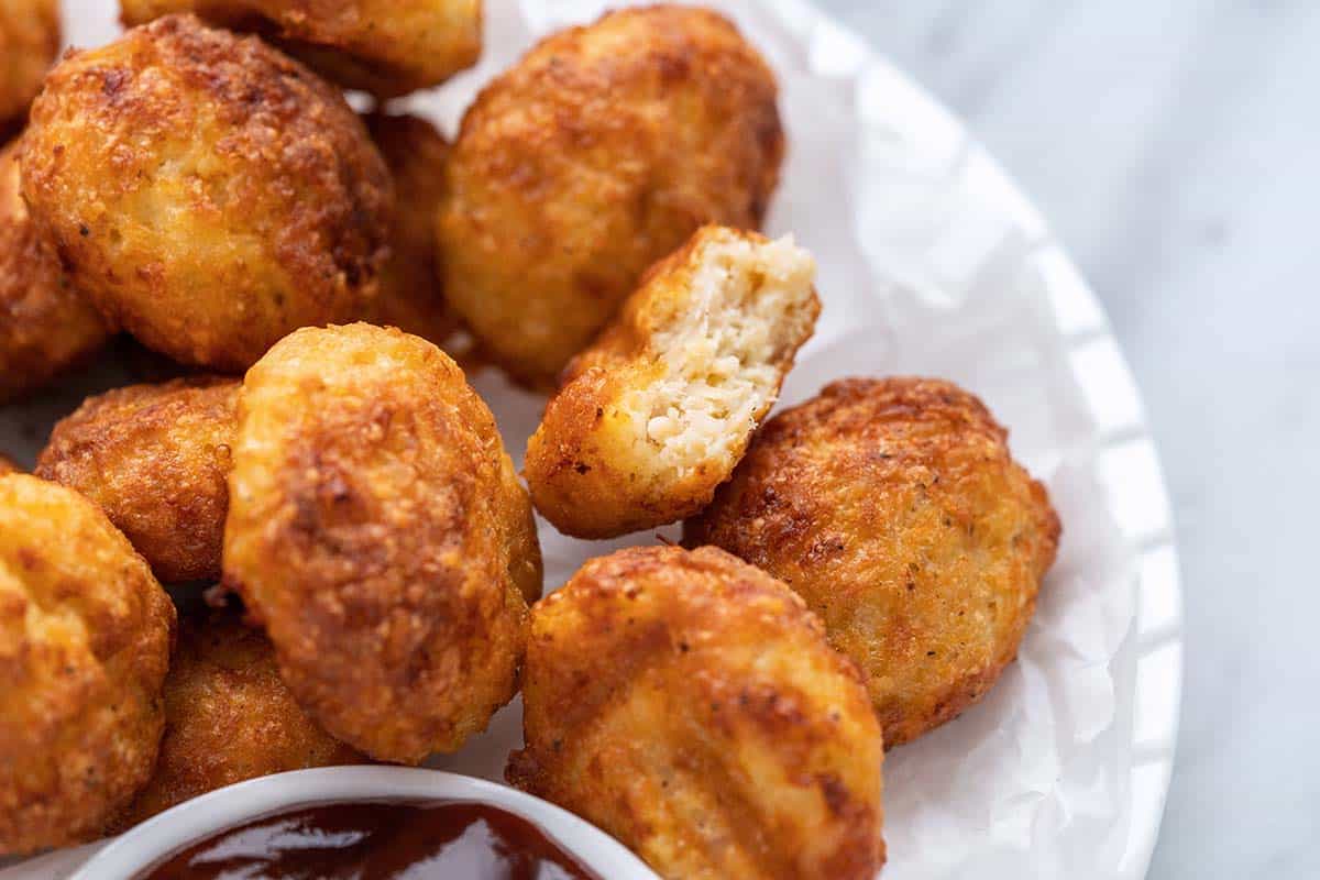 plate of air fryer chicken nuggets with bitten nugget showing inside