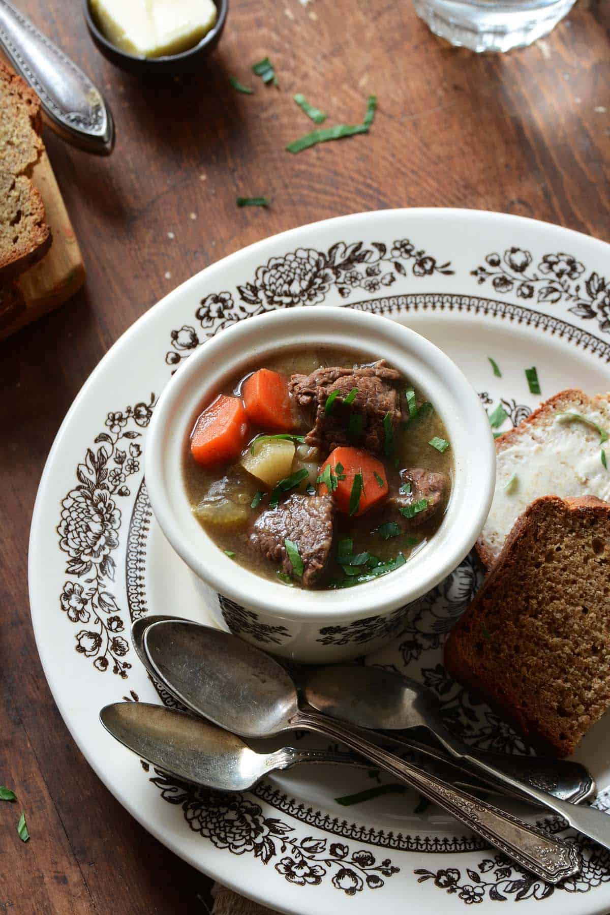 best irish beef stew recipe in flowered bowl with side of irish soda bread