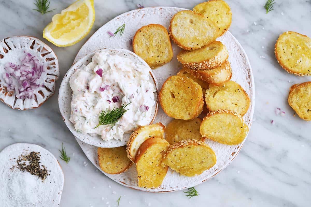 esy smoked salmon dip recipe with sesame bagel chips on rustic white ceramic plate