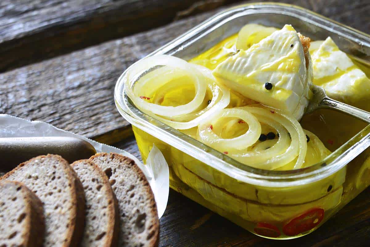 glass container with marinated czech camembert cheese