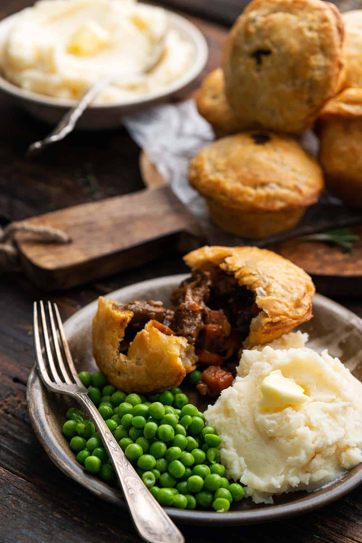 plate of beef pie with mashed potatoes and peas