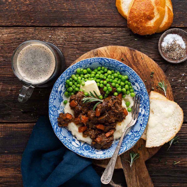 easy English beef stew recipe with ale and mushrooms served on mashed potatoes