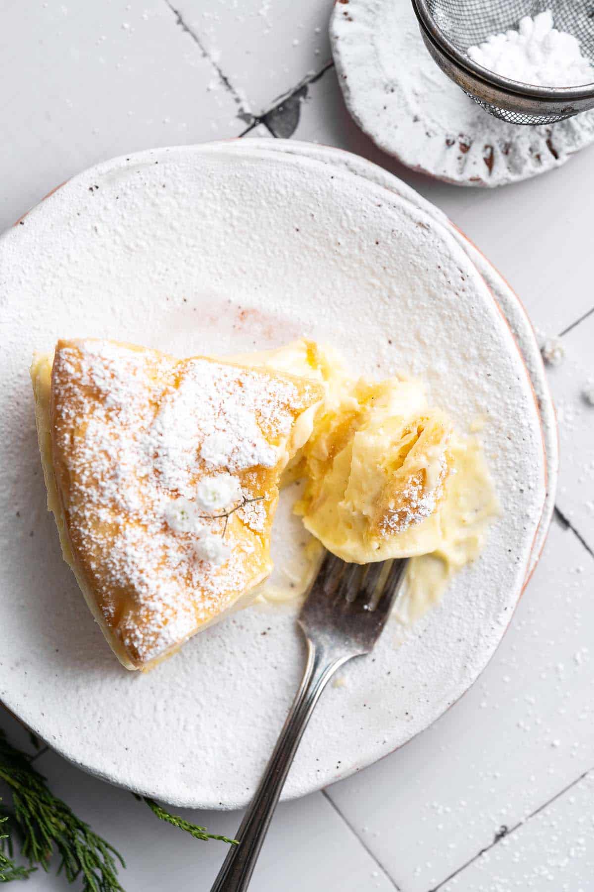 slice of cream puff cake on rustic stoneware plate with bite on a fork