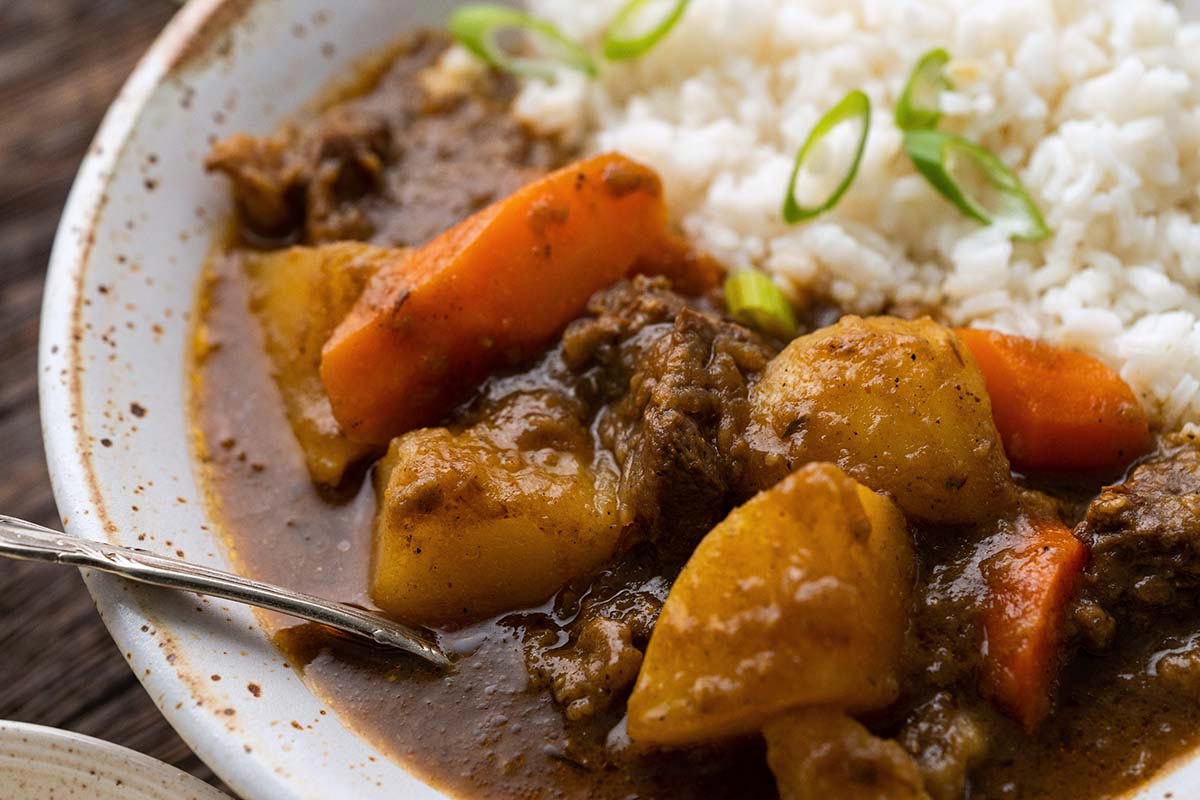 close up of dish of Japanese beef curry with vegetables and rice