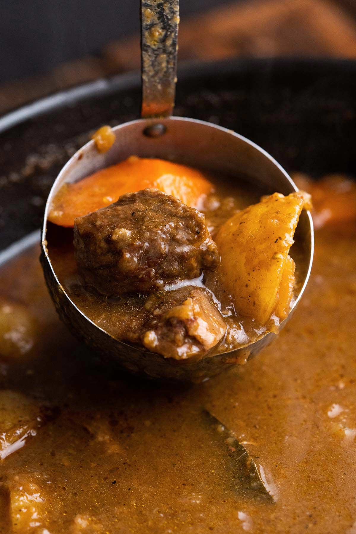ladle over pot of golden curry with beef