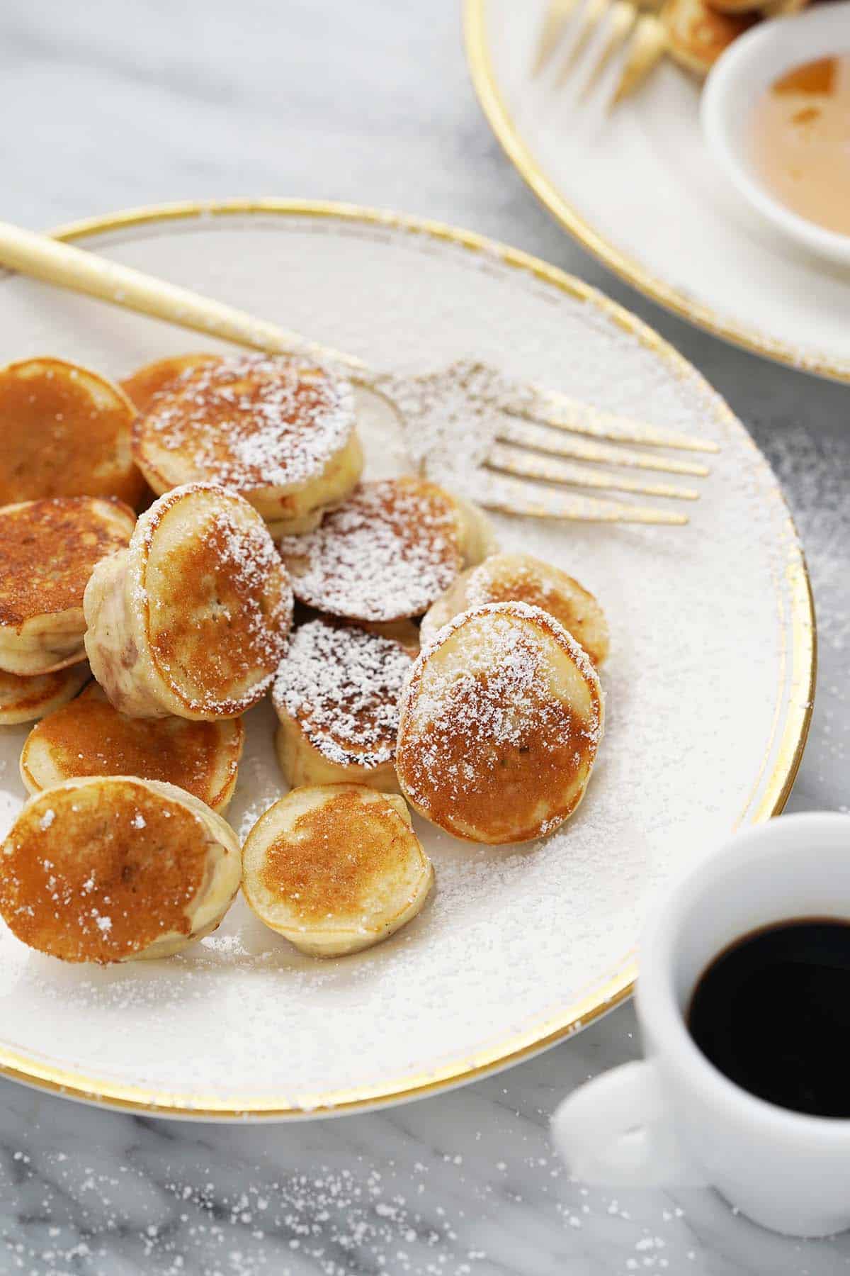 pancake covered banana slices on plate with powdered sugar sprinkled on top