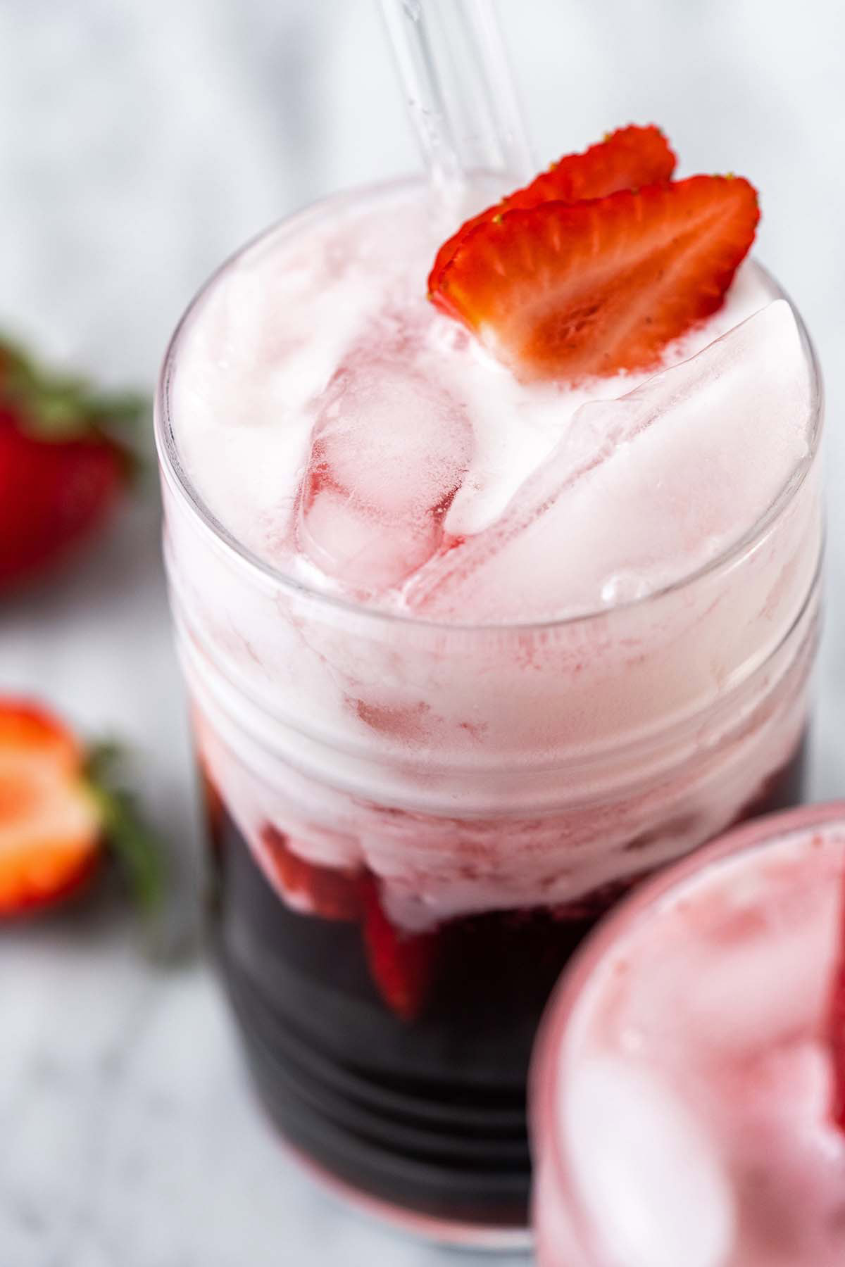 close up of strawberry boba tea drink with fresh strawberries